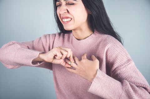 Frau versucht einen Ring vom Finger zu ziehen