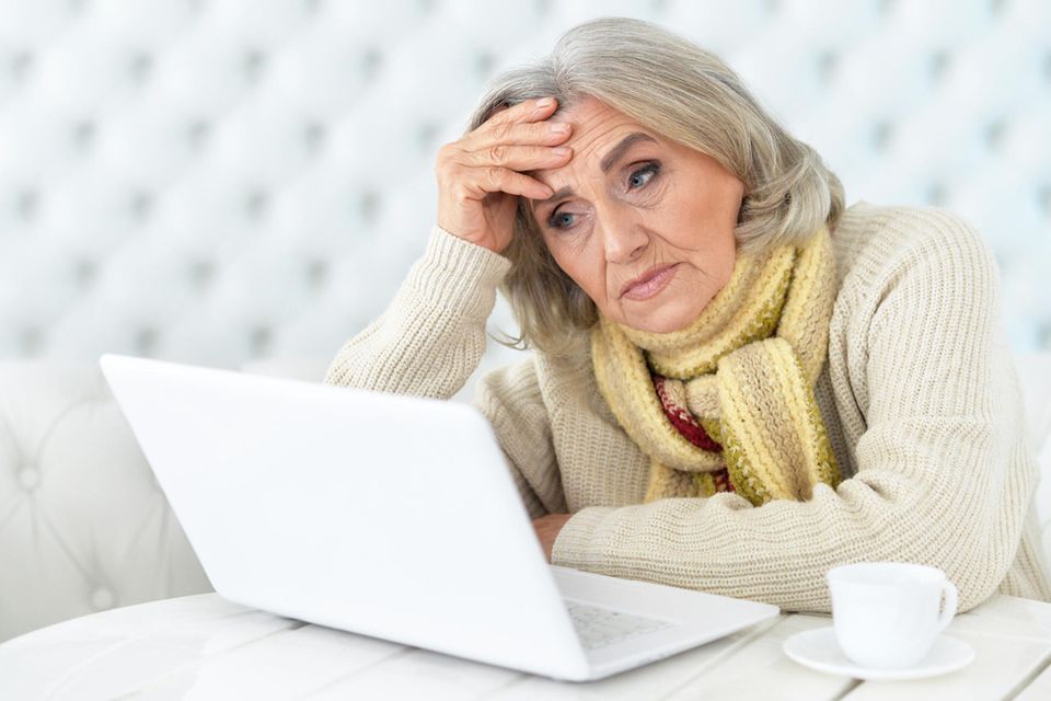 Ältere, verzweifelte Dame vor ihrem PC
