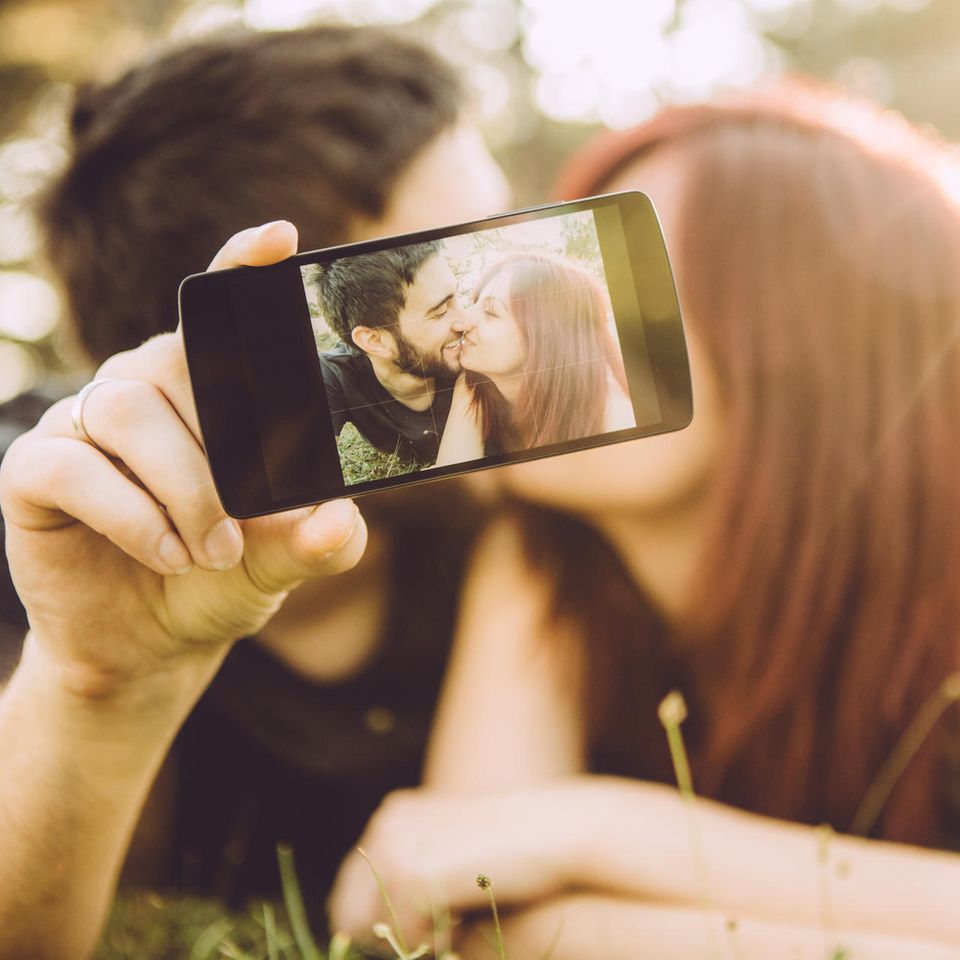 Liebe in sozialen Medien: Ein Paar küsst sich und macht dabei ein Selfie