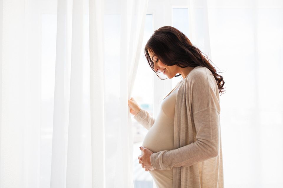 Mutterschutzfrist: Schwangere Frau vor Gardine