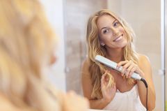 Haare glätten: Locken Haare Glätten: Frau mit Glätteisen