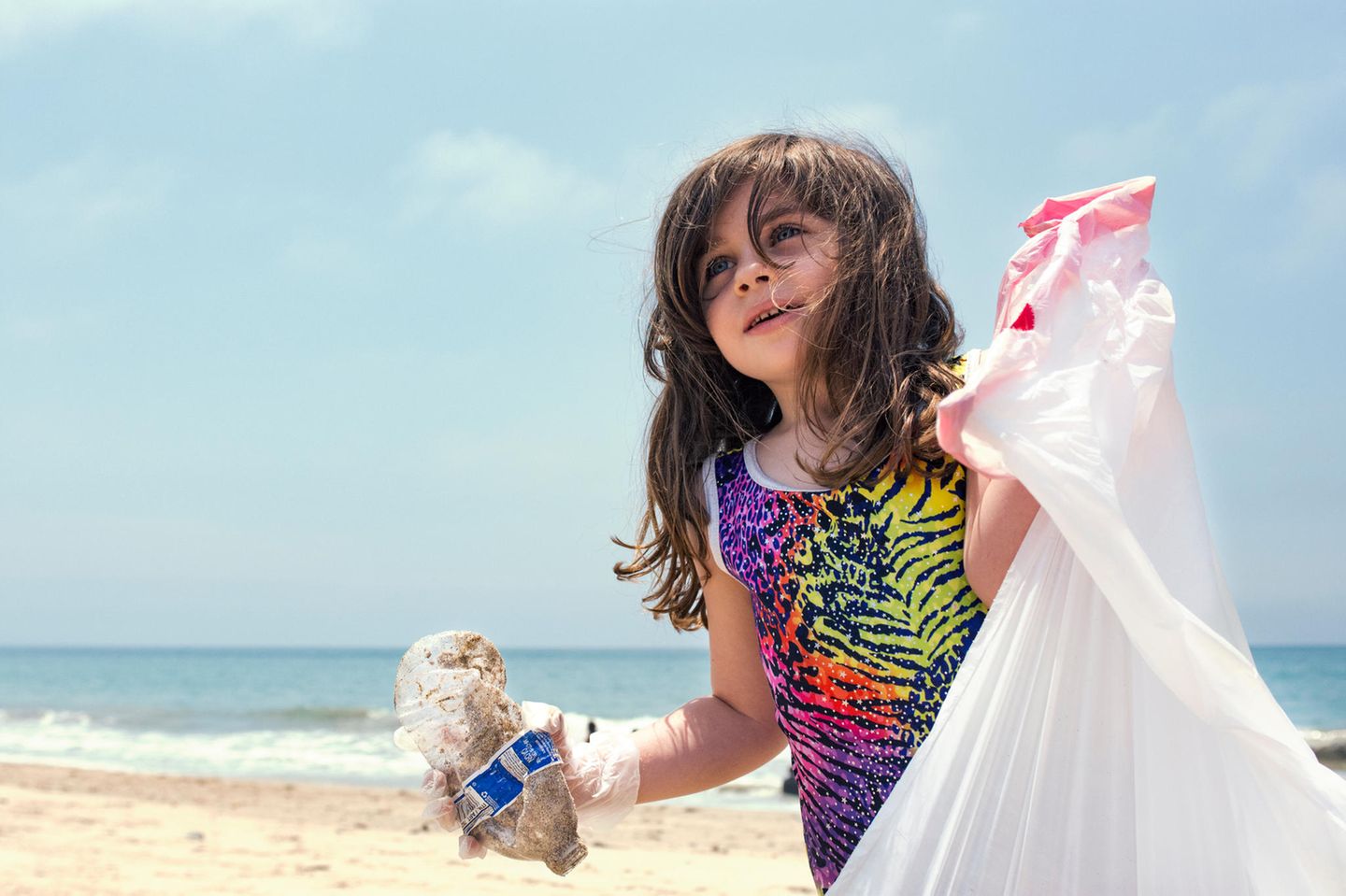 Von jungen Menschen lernen: Kind sammelt Müll am Strand ein