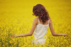 Naturkosmetik für die Haarpflege Rothaarige Frau im Rapsfeld