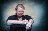 Gesichter der Depression: Frau sitzt auf Stuhl und weint