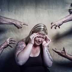 Gesichter der Depression: Frau umringt von Armen