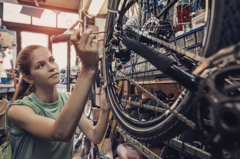 Fahrradmonteur: Frau repariert ein Fahrrad