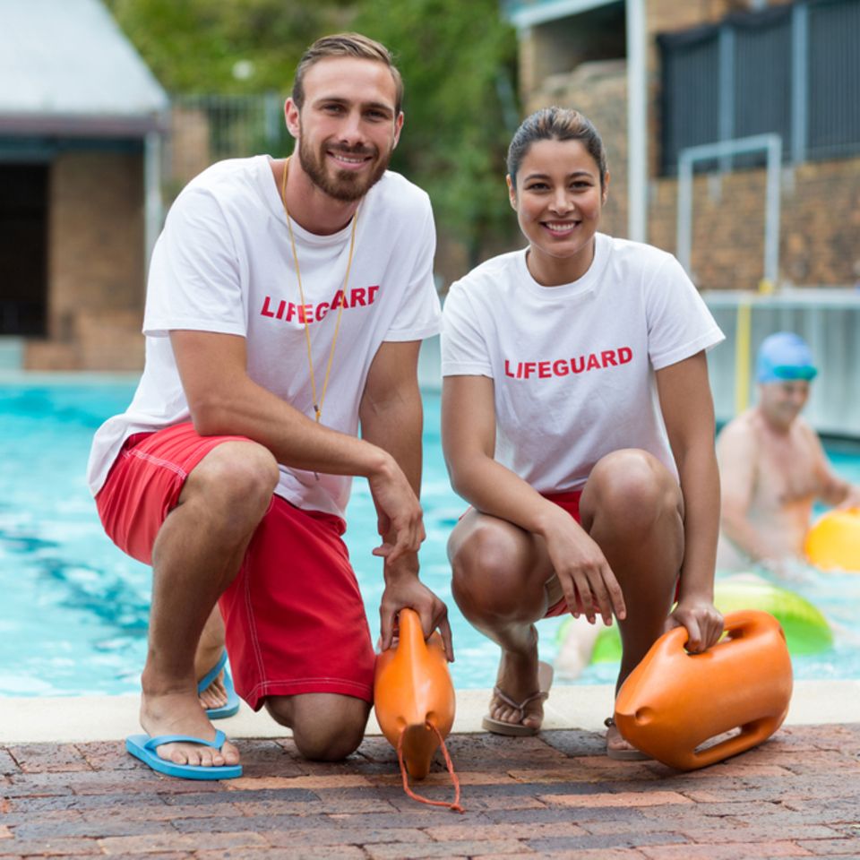 Bademeister: Zwei Rettungsschwimmer vor einem Schwimmbad