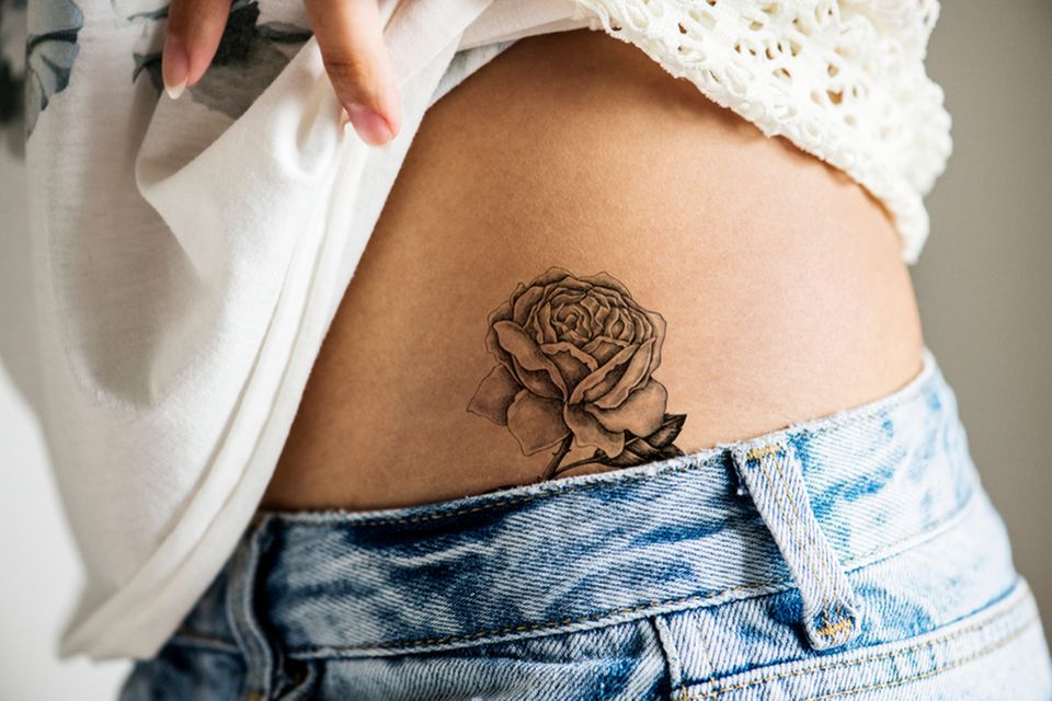 Tattoos an der Hüfte: Frau mit Rosen-Tattoo an der Hüfte