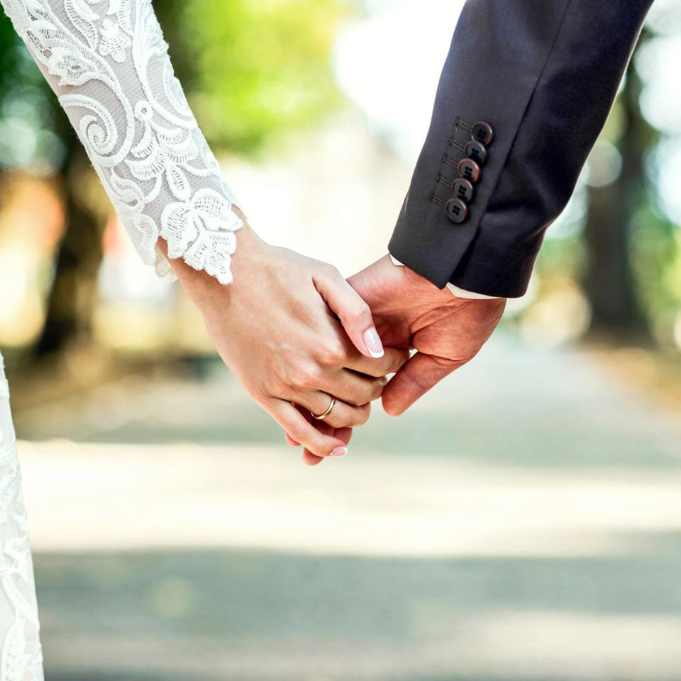 Gute Gründe zu heiraten: Ein Brautpaar hält Händchen