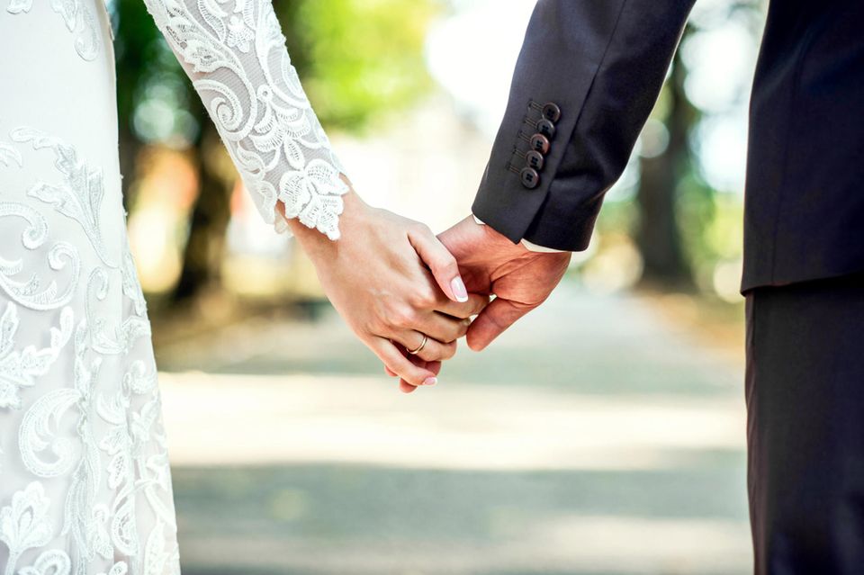 Gute Gründe zu heiraten: Ein Brautpaar hält Händchen