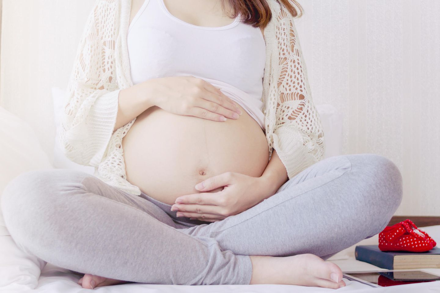 Corona aktuell: Schwangere Frau streichelt ihren Babybauch