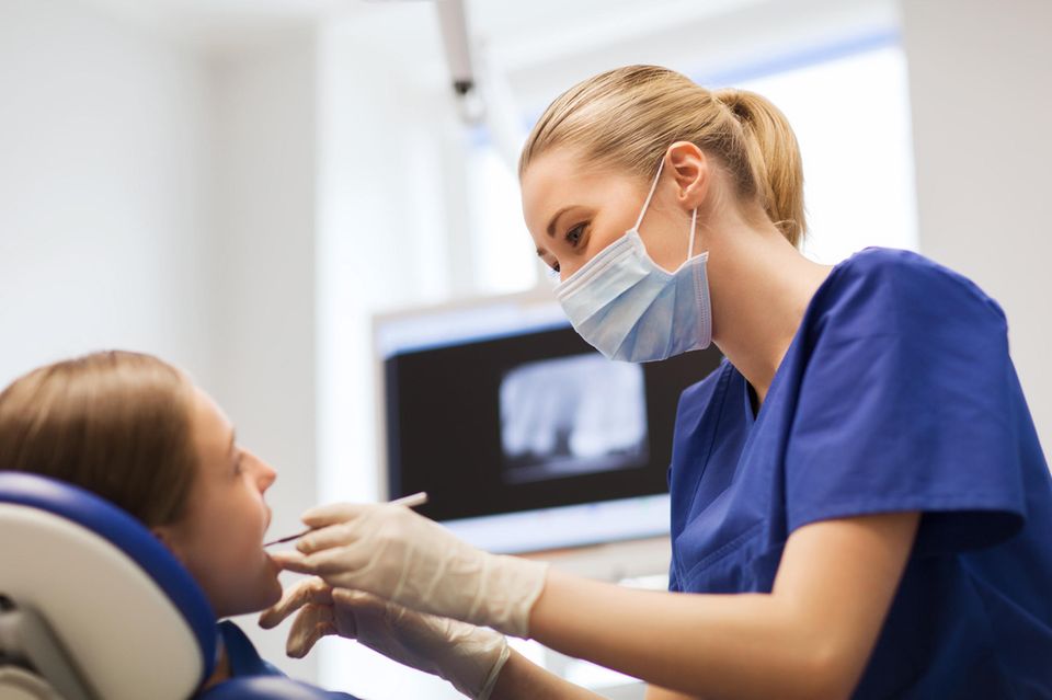Zahnarzt: Zahnärztin behandelt eine Patientin