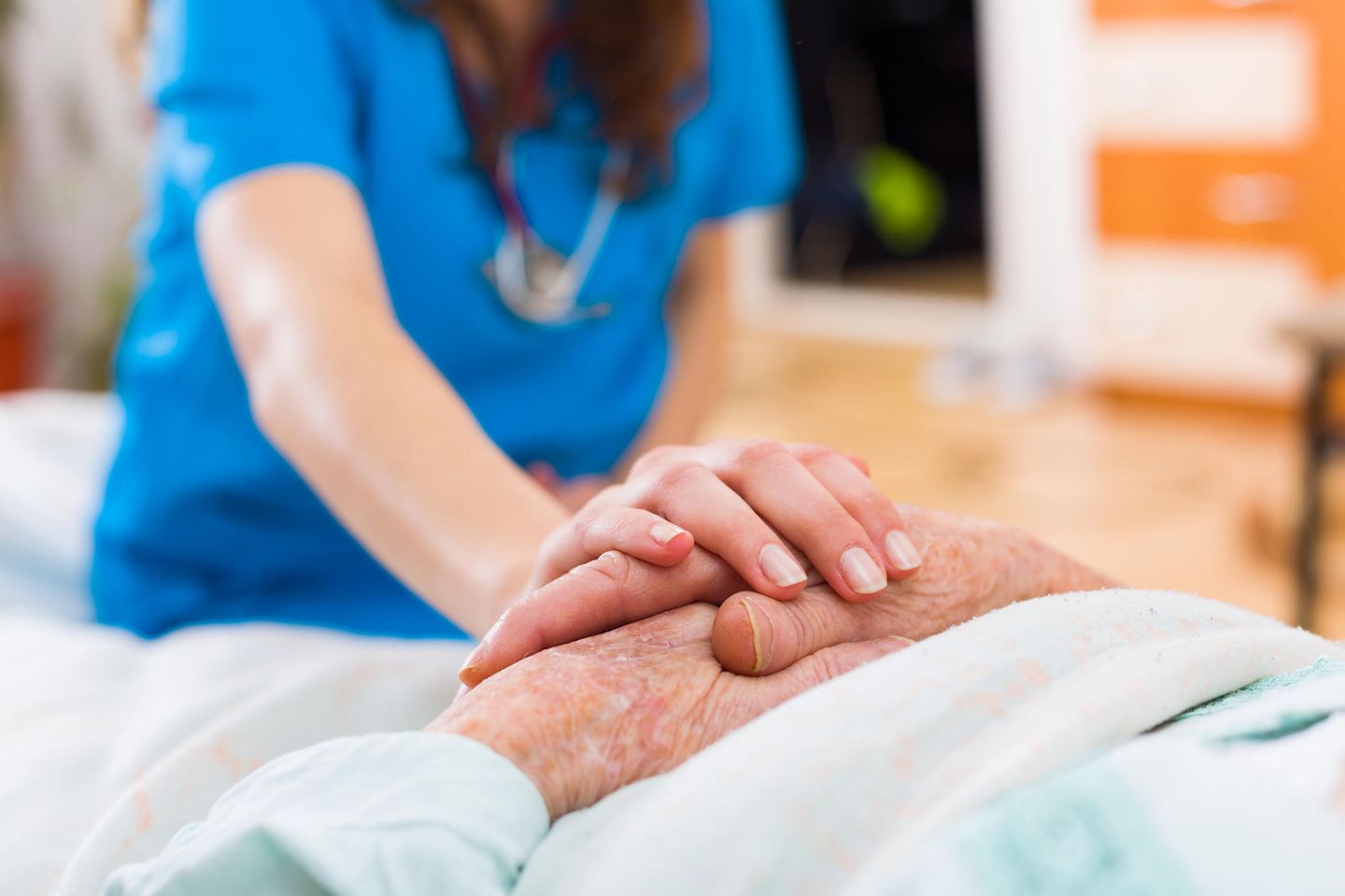 Seniorin im Krankenbett Pflegerin hält ihre Hand