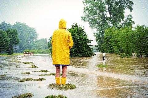 Klimaangst: Person im gelben Regenmantel und gelben Gummistiefeln im Regen