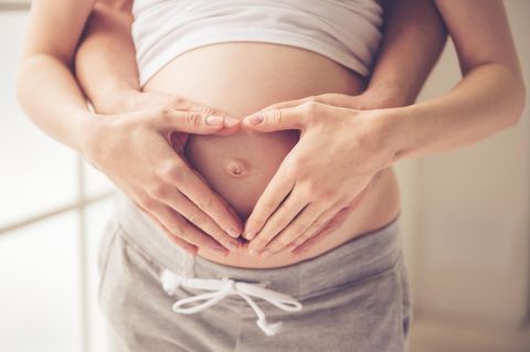 Corona-Krise & Elterngeld: Schwangere Frau mit Händen auf dem Bauch