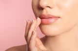 Ein transparentes Gloss bekommt mehr Wirkung, wenn noch etwas Lippenstift darunterkommt: die Lieblingsfarbe mit der Fingerspitze von innen nach außen zu den Lippenrändern auftupfen.