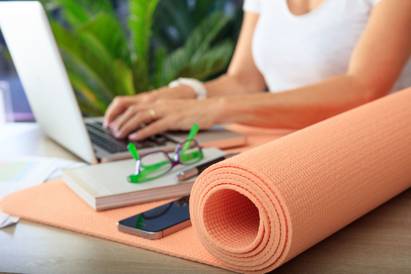 Yoga fürs Büro: Frau am PC mit Yogamatte