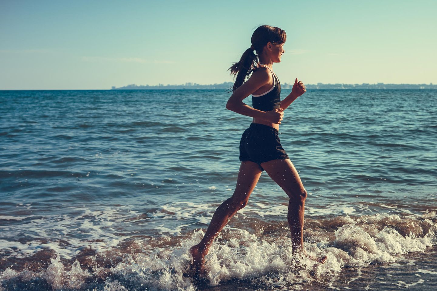 5 Elemente Workout: Frau joggt durchs Wasser
