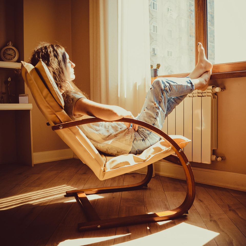 Singles in der Coronakrise: Eine Frau sitzt zu Hause auf einem Liegestuhl