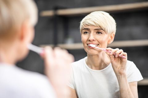 Zahnpflege in den Wechseljahren: Frau putzt sich die Zähne