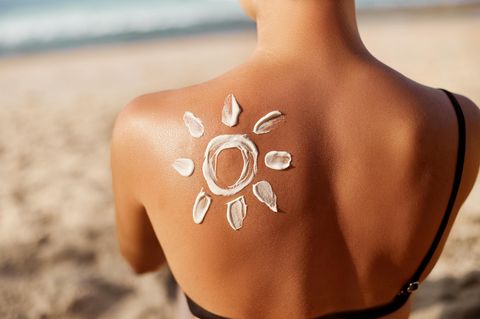 Sonnencreme-Fehler: Frau mit Sonnencreme auf dem Rücken