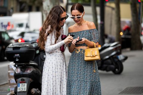 Günstige Onlineshops: Zwei Frauen auf der Fashionweek am Handy