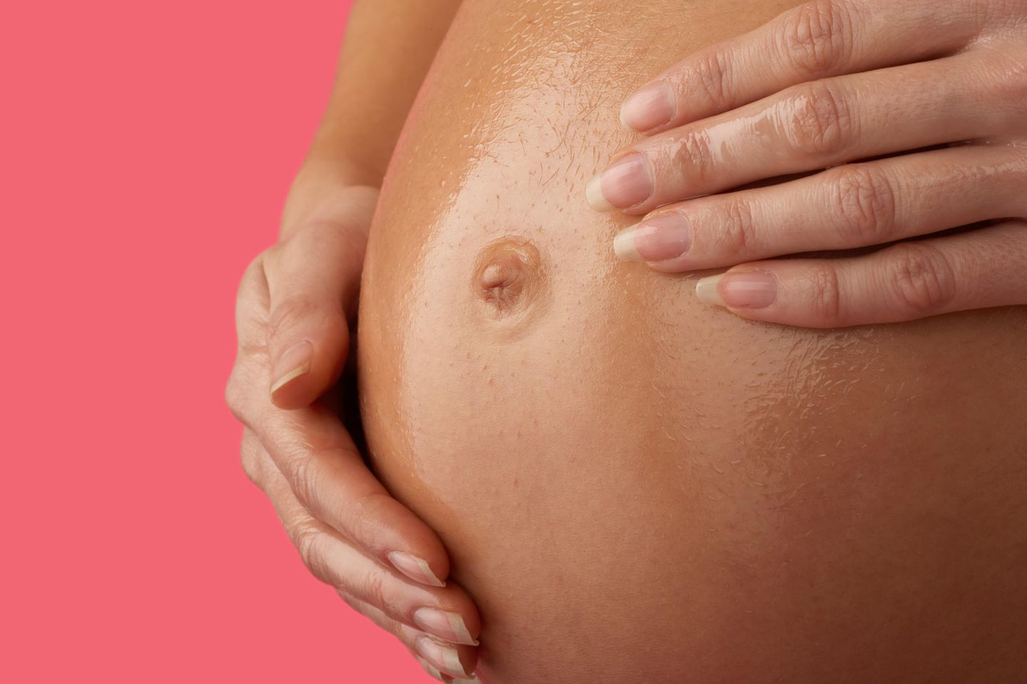 Schwangere ölt Bauch ein