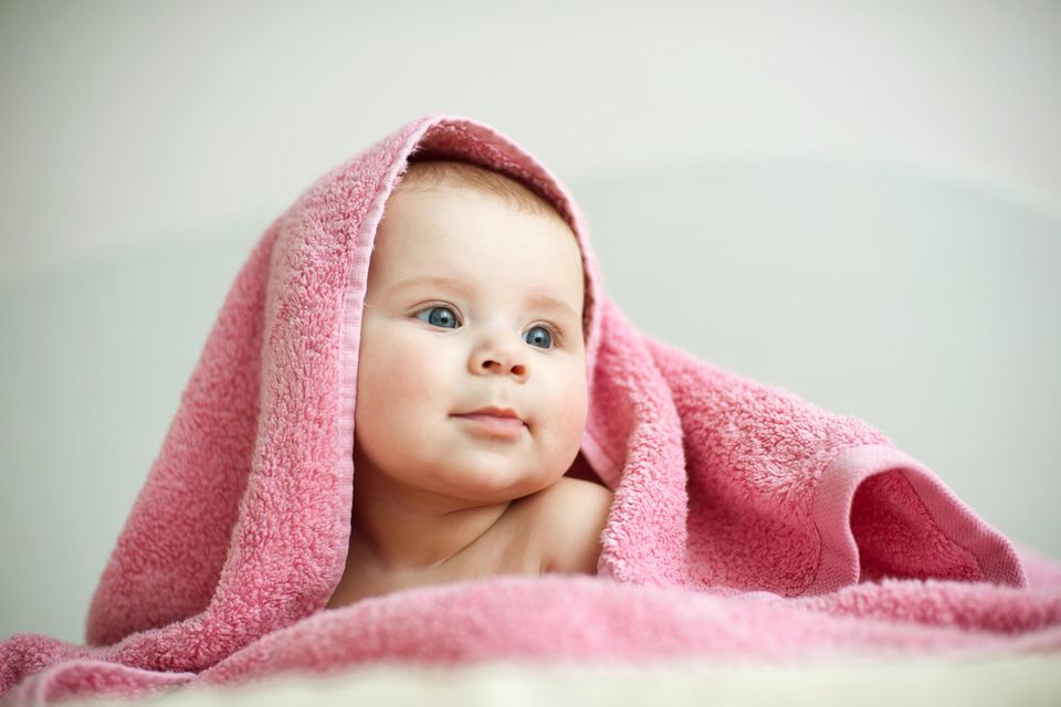 Estnische Vornamen: Baby unter rosafarbenem Handtuch