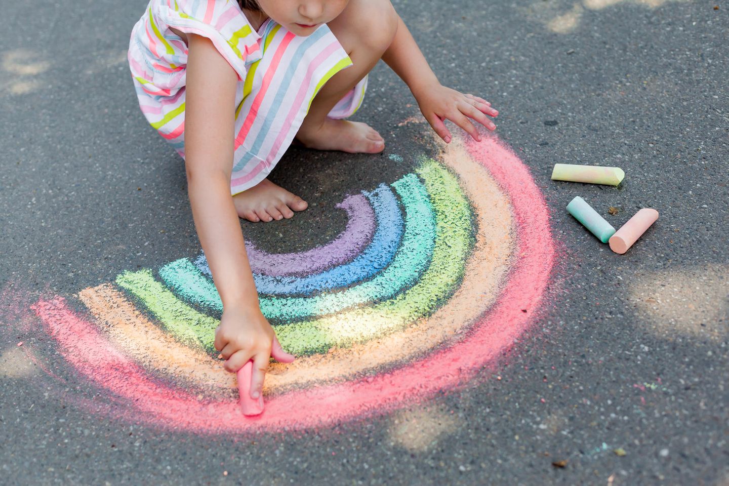 Kreide selber machen: Kind malt mit Kreide auf Straße
