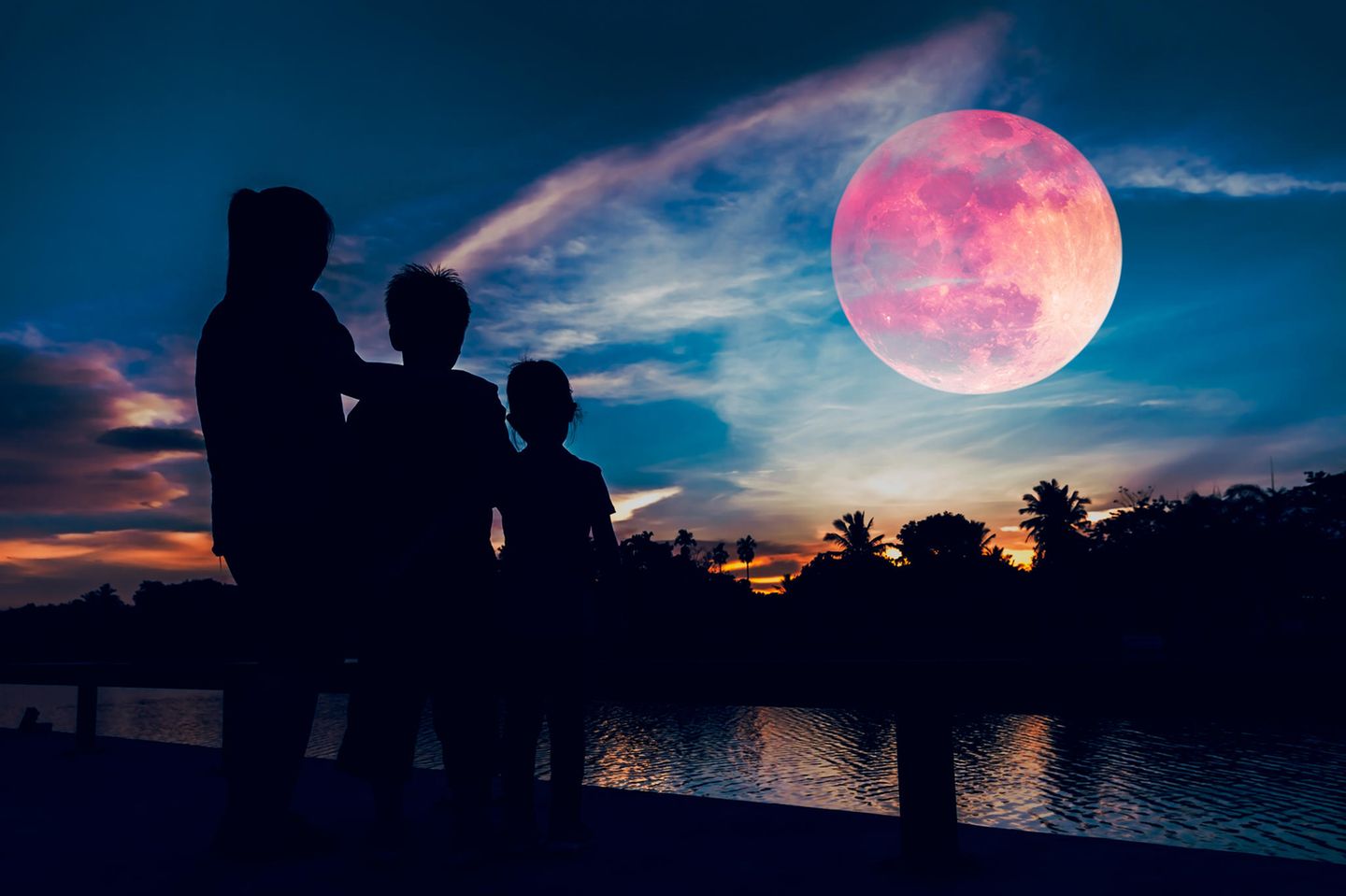 Horoskop: Drei Menschen schauen sich den Erdbeermond an
