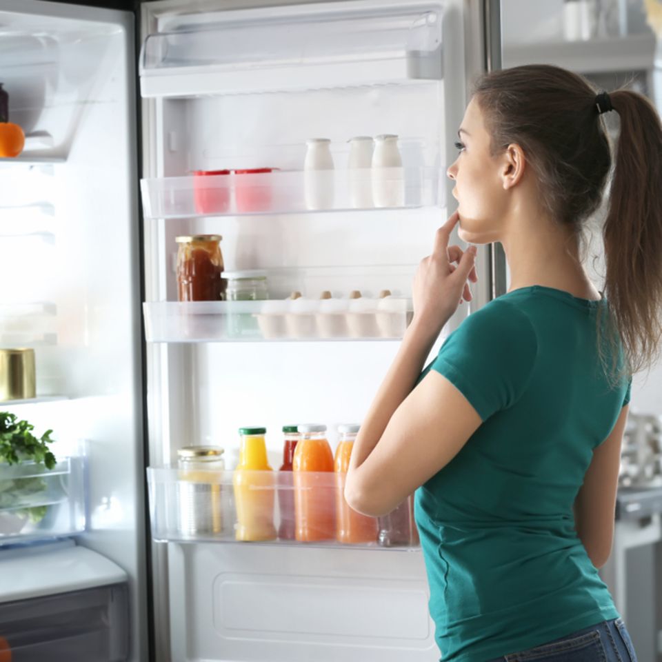 Kühlschrank Temperatur: Frau steht vor offenem Kühlschrank