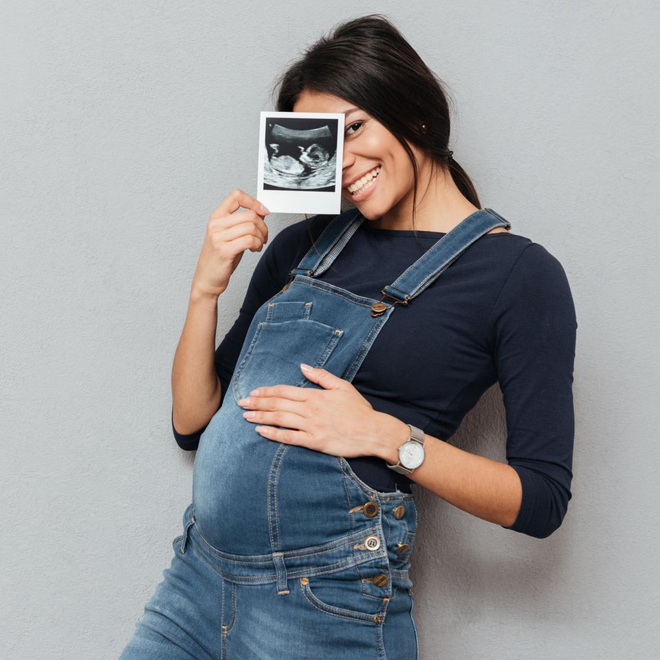 Schwangere mit Ultraschallbild in der Hand