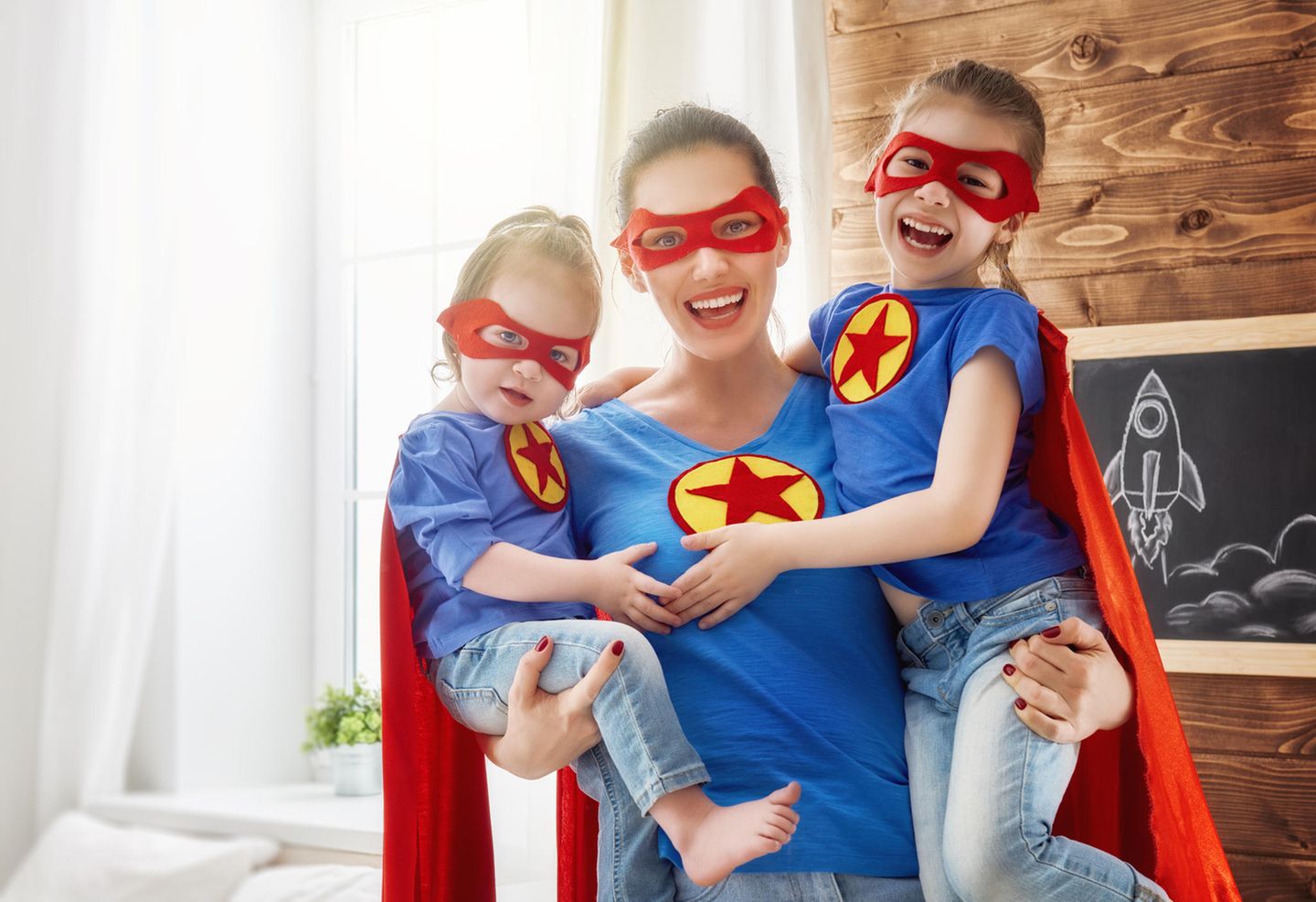 Freundschaft unter Müttern: Mama mit Töchtern auf dem Arm im Superman-Style