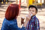Freundschaft unter Müttern: Mutter wischt den Mund ihres Sohnes sauber