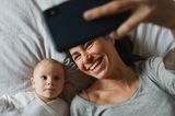 Freundschaft unter Müttern: Mutter fotografiert sich und ihr Baby mit Smartphone