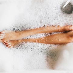 Burnout Prävention: Beine einer Frau in Badewanne