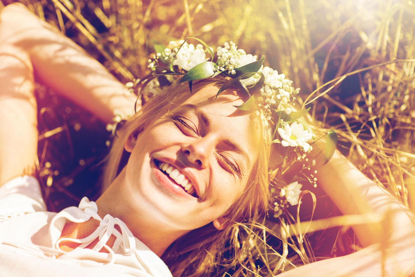 Horoskop: Eine glückliche, schöne, junge Frau mit einem Blumenkranz im Haar