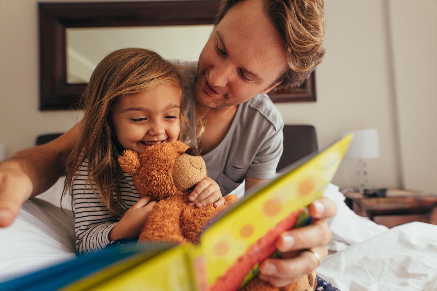 Schlafprobleme bei Babys und Kleinkindern: Vater liest Tochter ein Buch vor