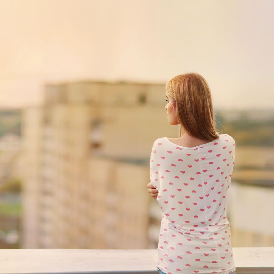 Unsicherheit: Eine einsame Frau auf einem Dach