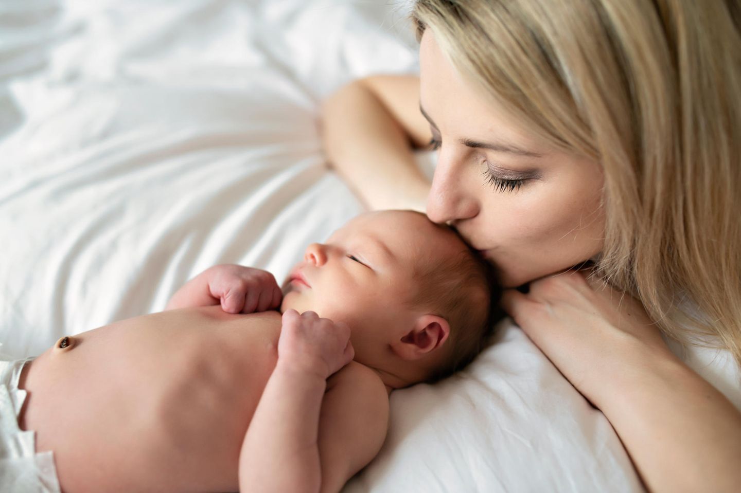 Familienleben: Mutter küsst ihr Baby
