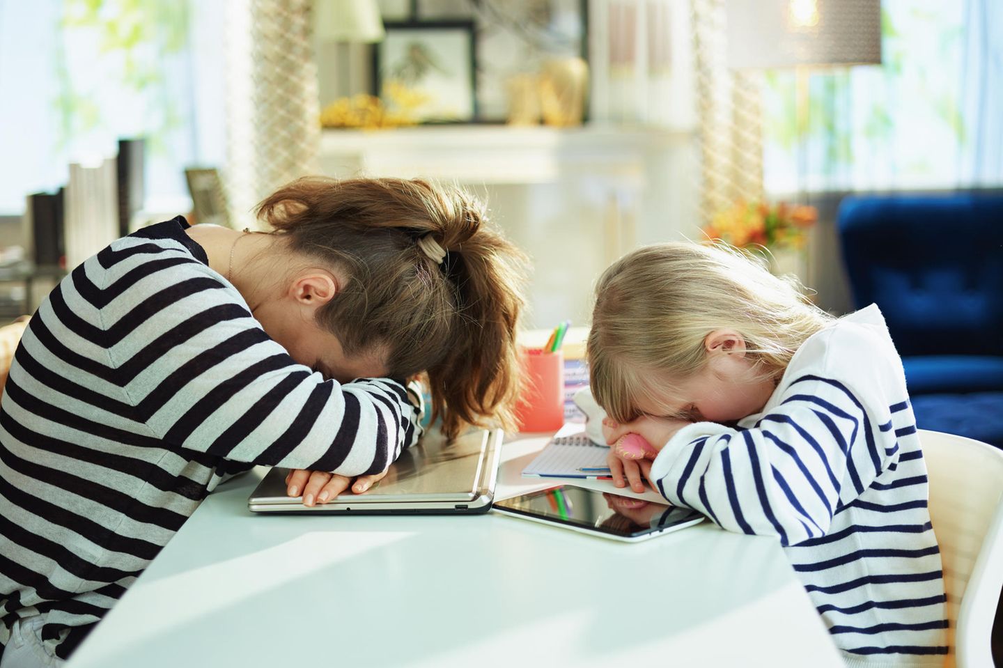 Homeoffice plus Homeschooling geht gar nicht: Mutter und Tochter legen Kopf auf den Tisch