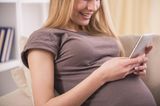 Geburt: Schwangere Frau mit Handy