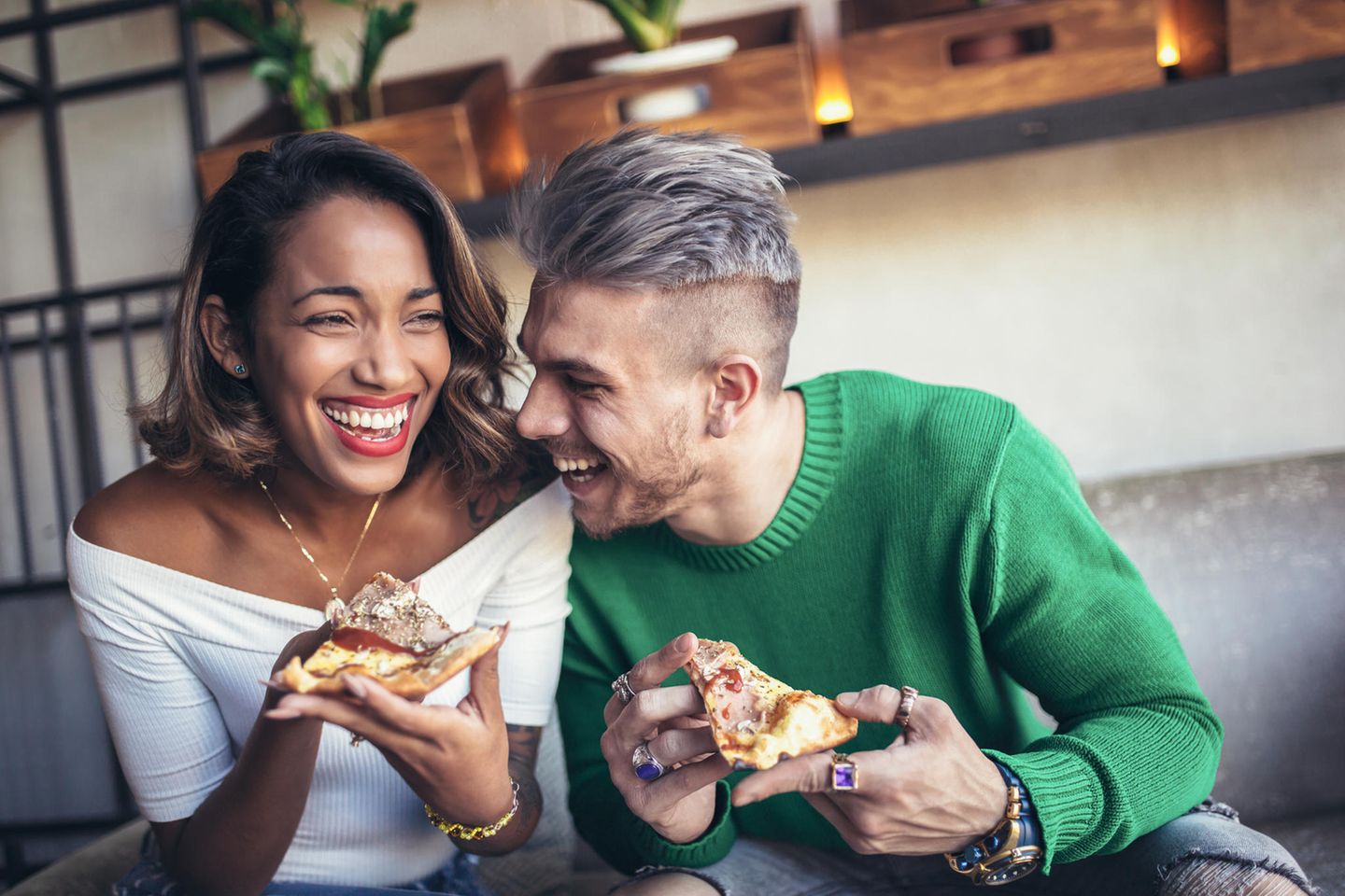 Pizza vom Vortag: Pärchen isst Pizza auf dem Sofa