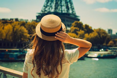 Paris-Syndrom: Eine junge Frau von hinten, die sich den Eiffelturm anschaut