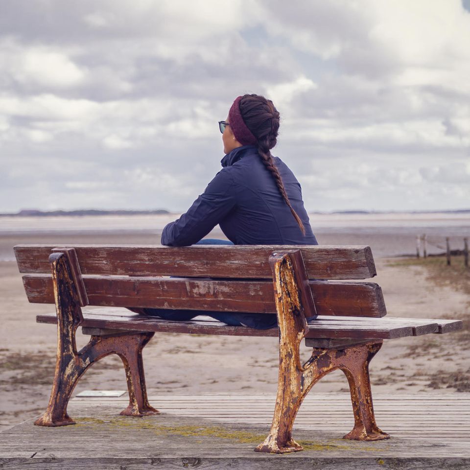 Guy Winch: Eine einsame Frau auf einer Bank am Strand