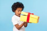 Kindergeburtstag: Kind öffnet Geschenk
