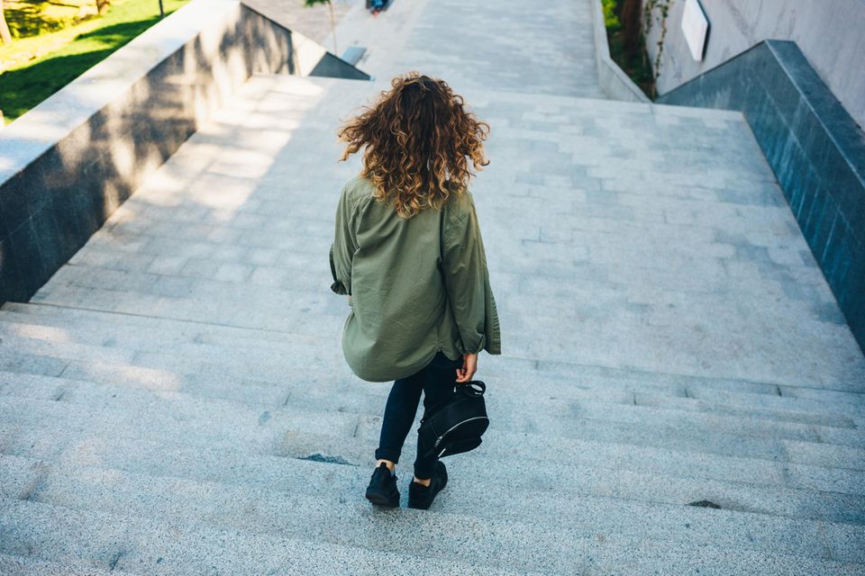 Bummeln: Frau geht Treppe herunter