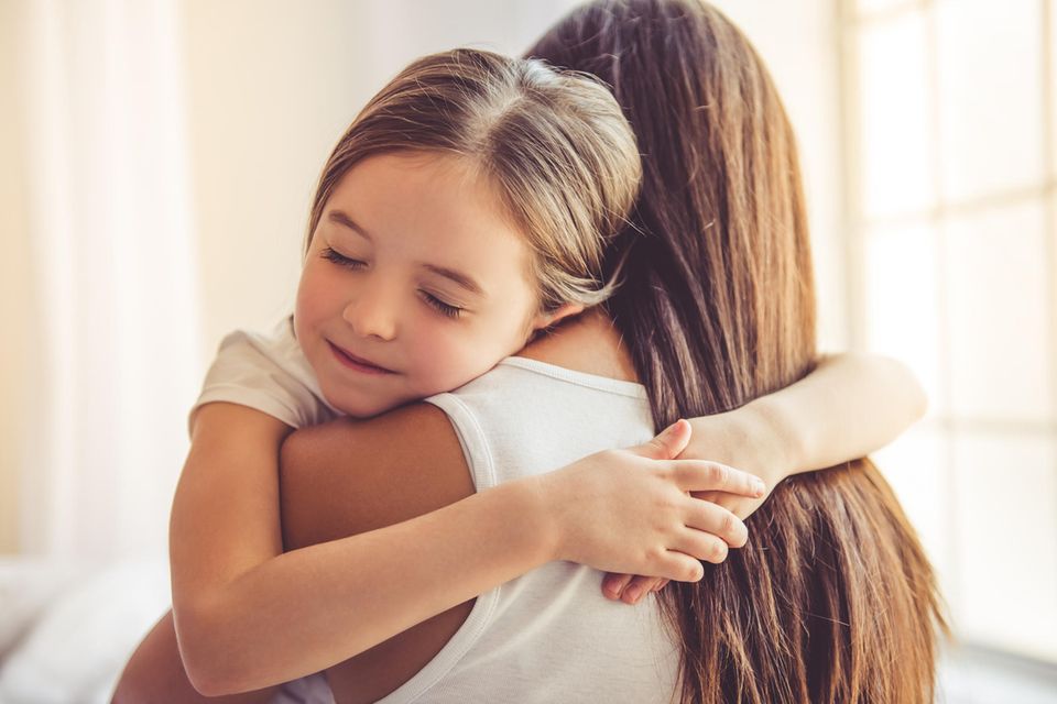 Familienleben: Tochter umarmt ihre Mutter