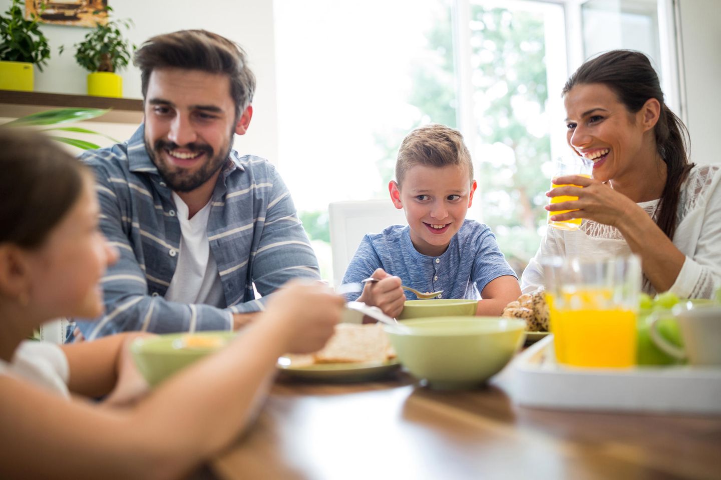 Familienleben: Familie sitzt zusammen am Essenstisch