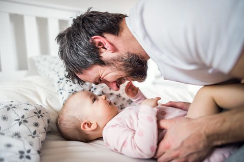 Familienleben: Vater knuddelt Baby
